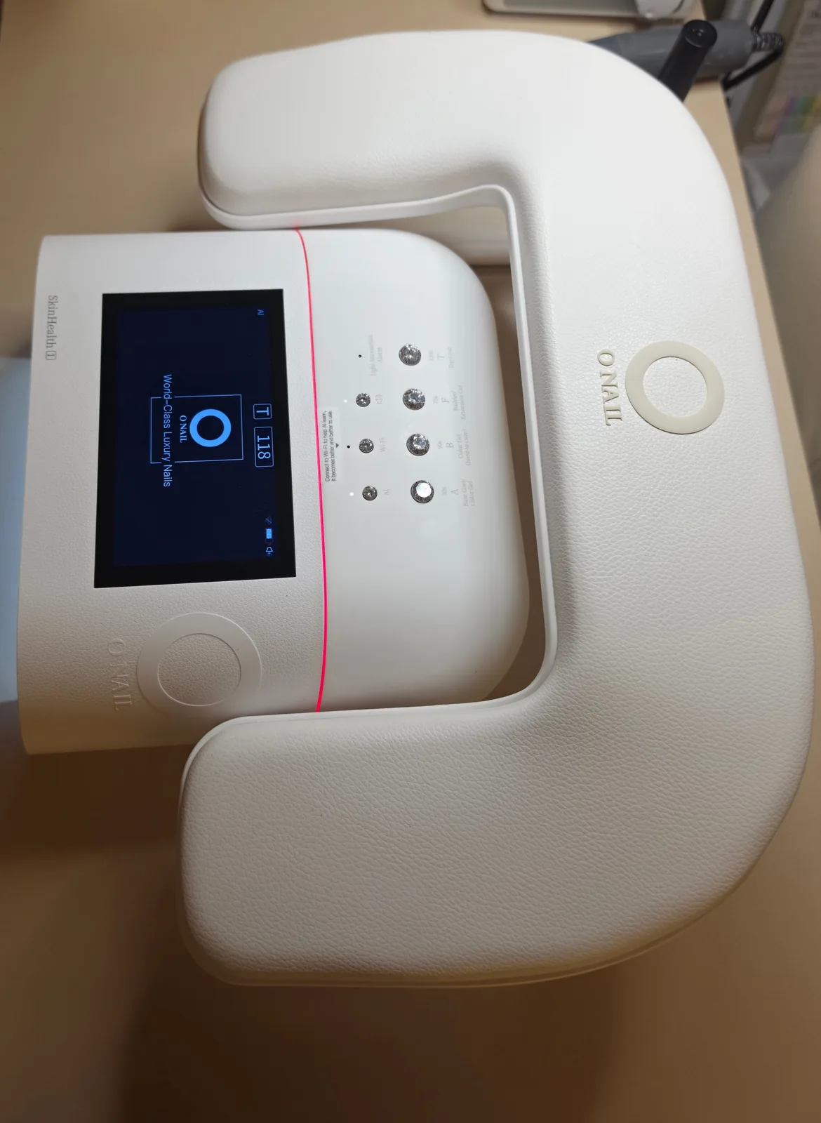 Cabine japonesa O NAIL vista de cima, com o painel digital aceso, na bancada do estúdio