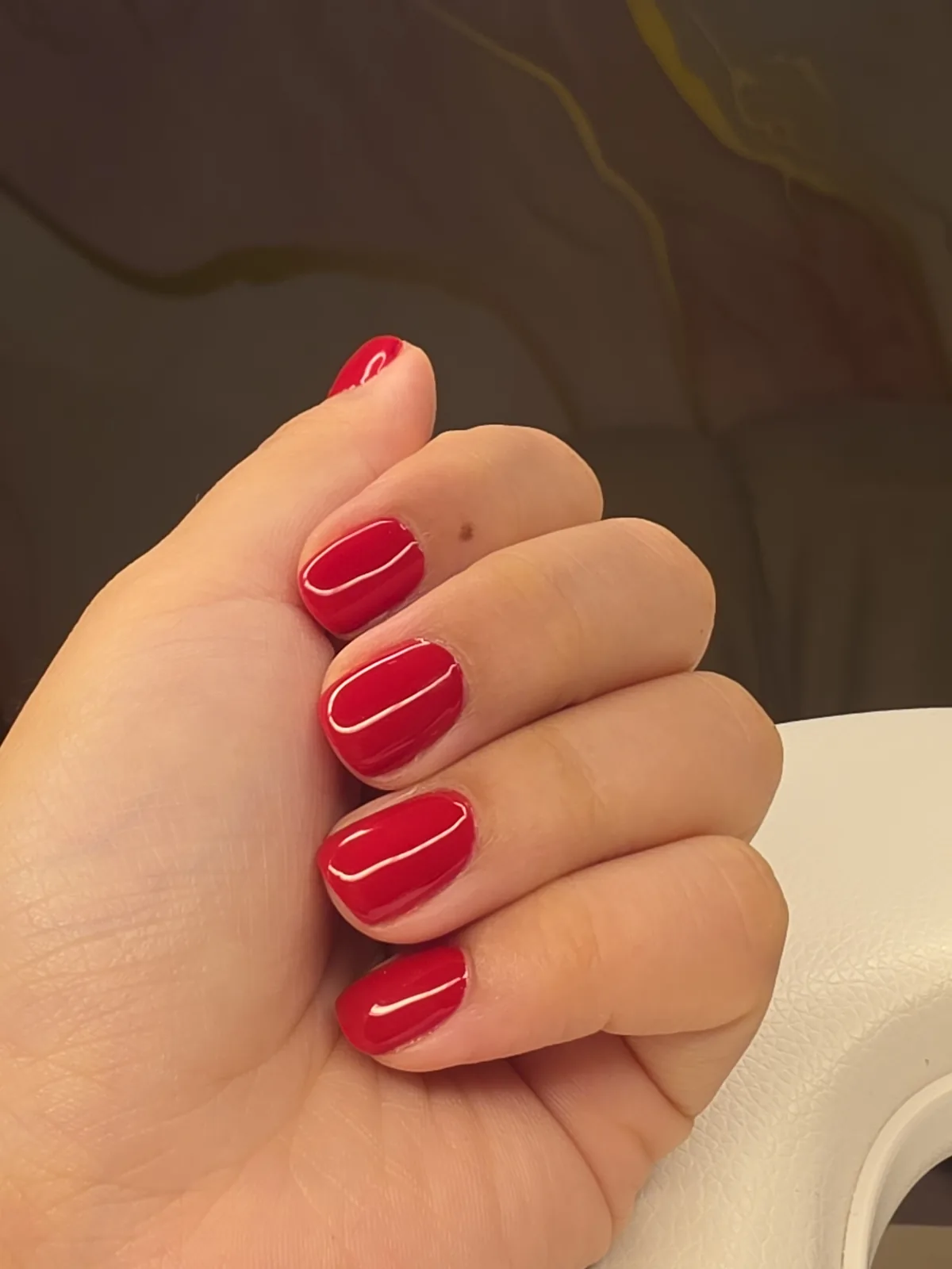 Esmaltação em gel vermelho clássico em unhas curtas arredondadas, com brilho alto, feita no estúdio em Jundiaí