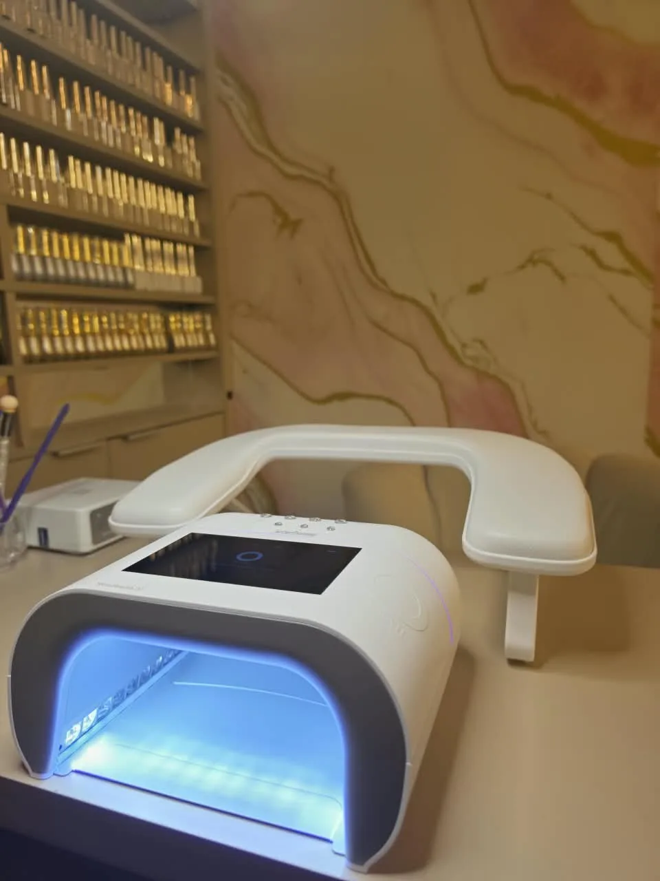 Cabine O NAIL acesa e prateleira de géis no estúdio, em Jundiaí